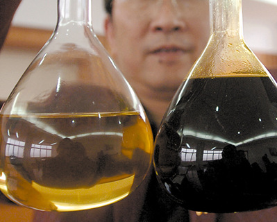 工作人员在展示利用“地沟油”（右）生产的生物柴油（左）。